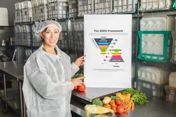 Dr Lisa Sossen pointing to the IDDSI Framework information board