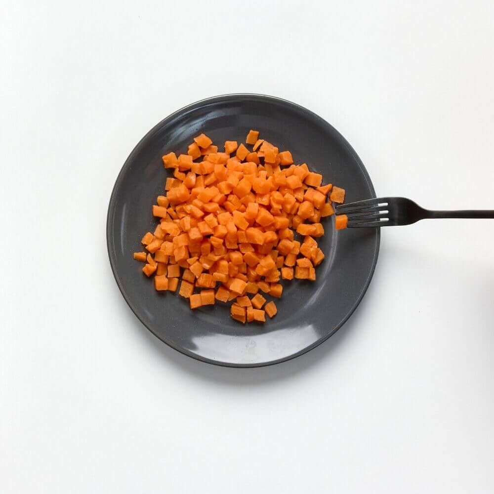Soft and bite-sized carrot on a plate with fork