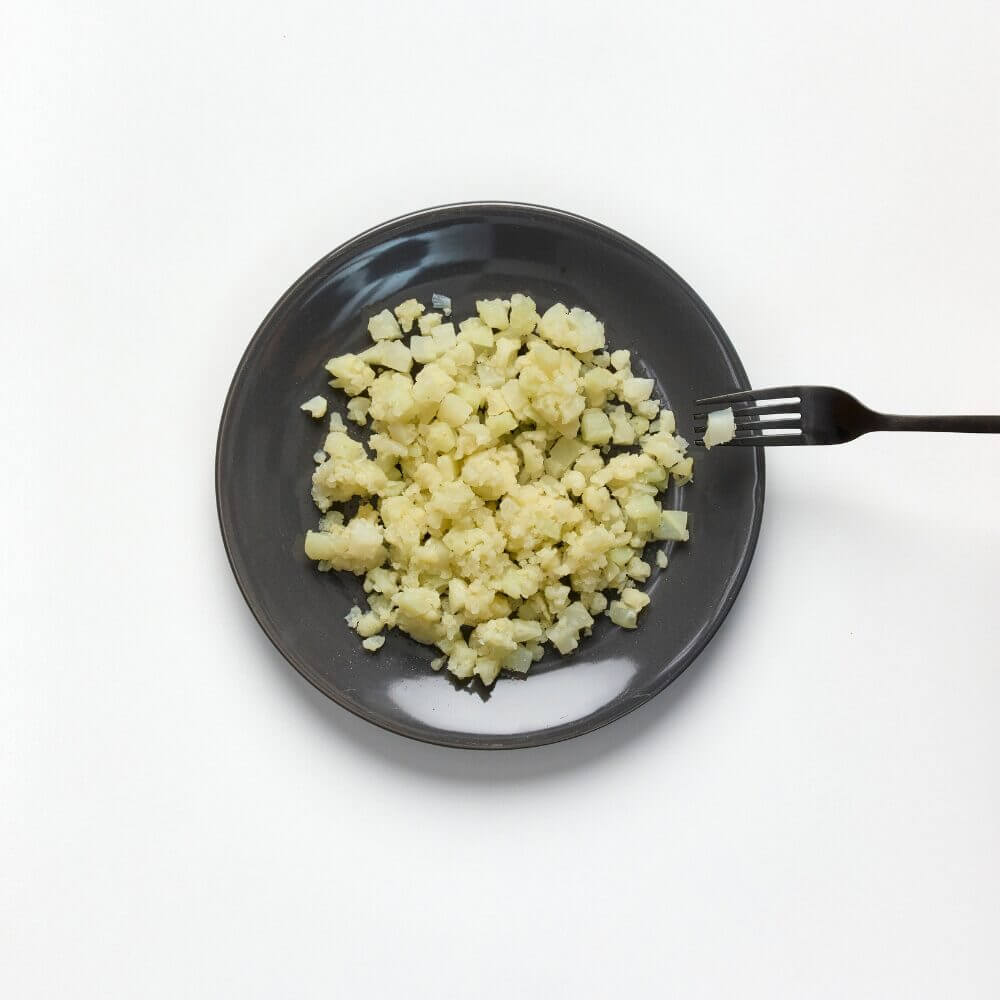 Soft and bite-sized cauliflower on aplate with a fork