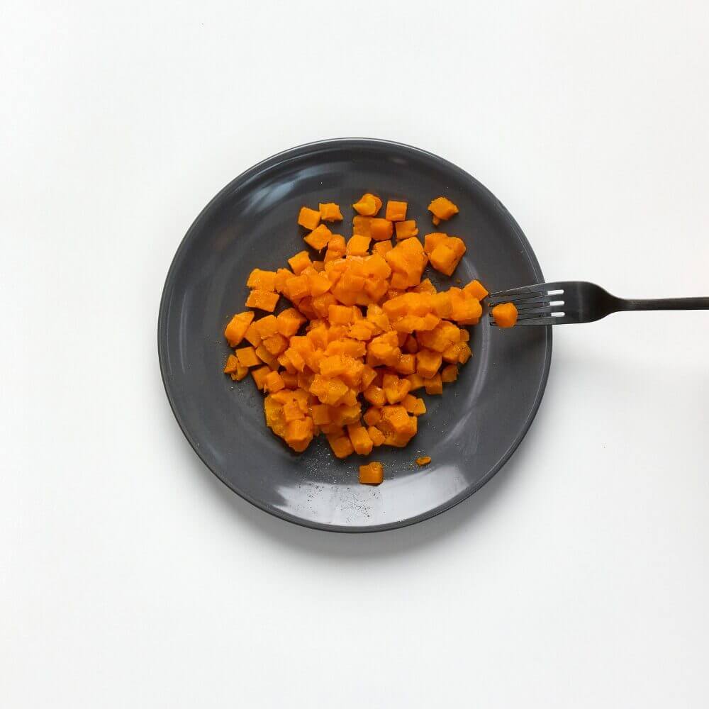 Soft and bite-sized sweet potato on a plate with fork